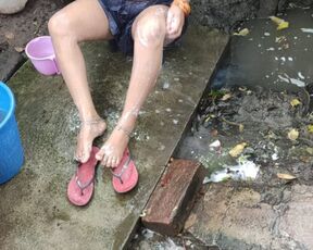 Indian house wife bathing outside with