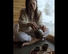 A girl filling tea into a classic cup